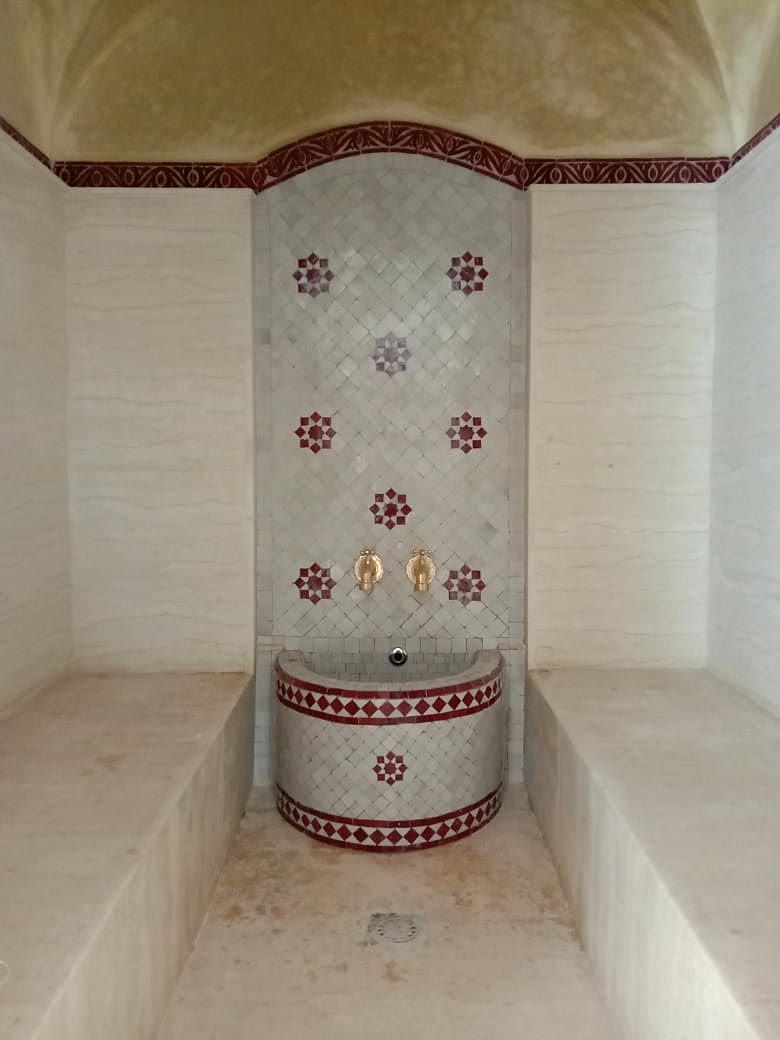 Hammam à coupole, fontaine en zellige rouge et blanc